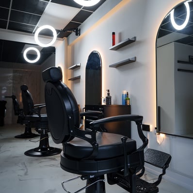 Inside of empty clean and new barbershop, chairs mirrors and LED accent lights
