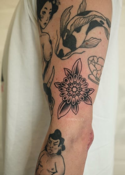 Old school flower tattoo design on the side of the arm