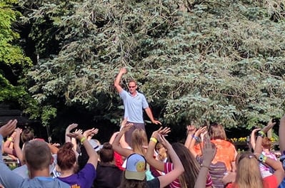 Johnny teaching children Tai Chi outdoors on a picnic table at Make Arthritis Stop Hurting Camp