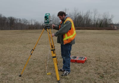 a man in a safety vest and a tripodod