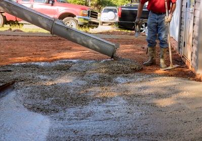 a man is pouring cement into a concrete wall