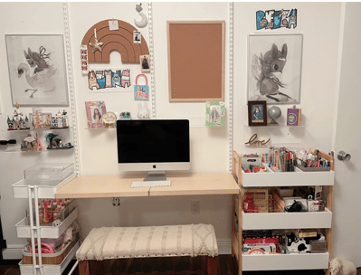 Organized kids’ study area with craft carts, art supplies, computer desk, and wall decor.