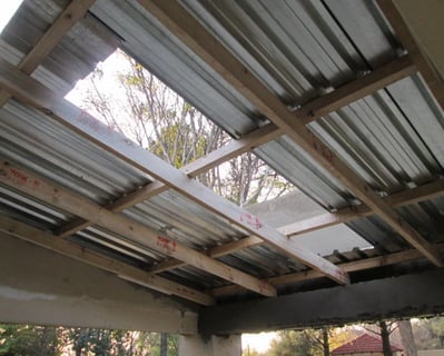Metal sheet installation over compliant timber purlins