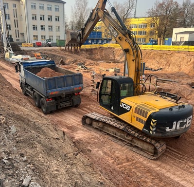 ekskavatorius krauna gruntą į sunkvežimį