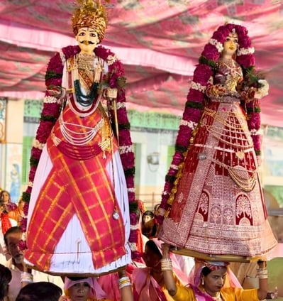 Two women with Gangaur Devi Devta on their heads, accompanied by the Manohar Brass Band.