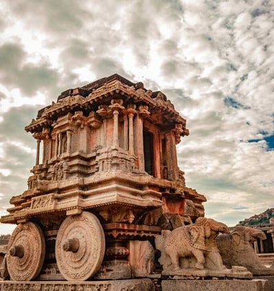 The chariot rests on two massive wheels, pulled by elephants further emphasizing its unique design.