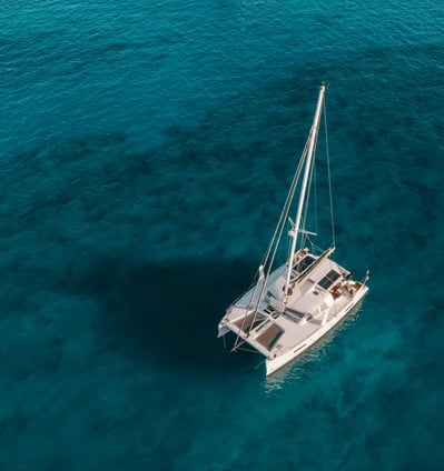 a sailboat in the ocean with a sailboat in the water