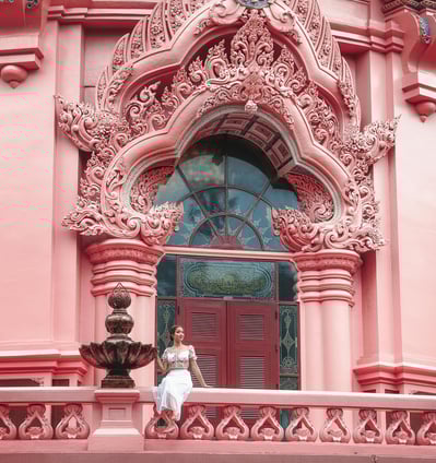 a woman in a white dress sitting on a balcony