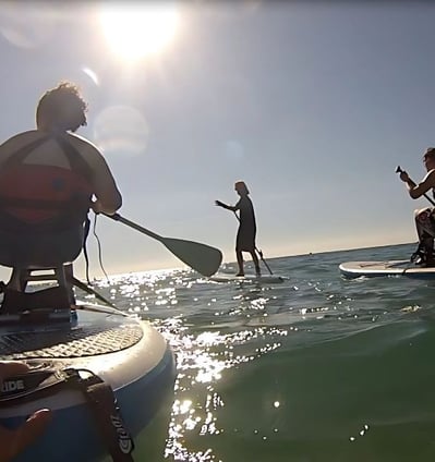 a man and woman paddle boarding in the ocean