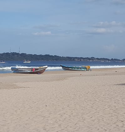 a beach with several boats and a boat in the water