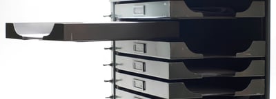 A black and white image of a set of documents drawers with one open drawer