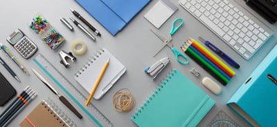 a desk with a keyboard, notebook, and a keyboard