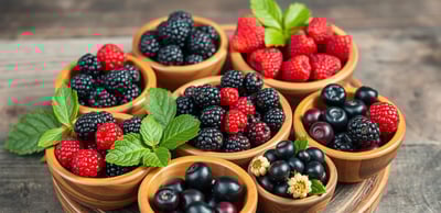 different wild berries in wooden bowls