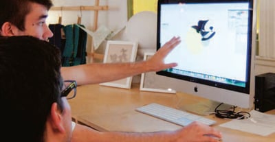 a man sitting at a desk with a computer monitor and a keyboard