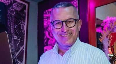 a man in a white shirt and glasses is holding a laptop