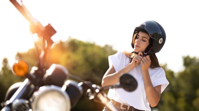mujer poniéndose un casco de moto