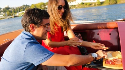 A couple enjoying wine and snacks on the James Bond–style speedboat Eskrok