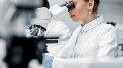 a woman in a lab coat and a microscope