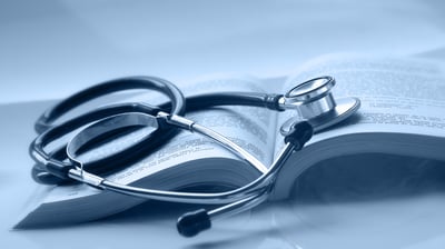 An open medical book with a stethoscope on top of it