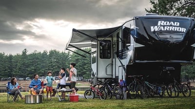 a group of people sitting around a campervan
