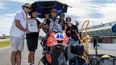 a group of people standing around a motorcycle