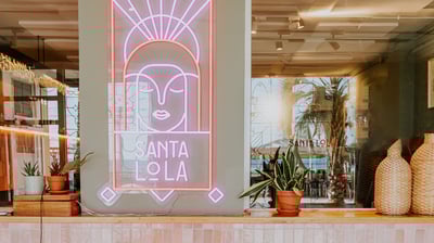 Interior del restaurante Santa Lola con neón rosa iluminado
