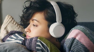 a woman laying on a couch with headphones on