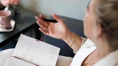 a woman sitting on a couch with a notepad and a pen
