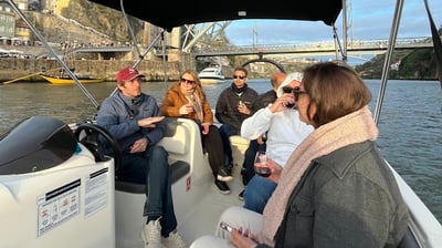 Guests chatting with Captain Francisco on Endure, with Porto’s Dom Luís I Bridge in the background