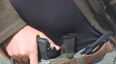 Man grips defensive firearm from concealment.