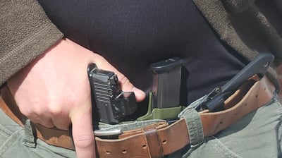 Man grips defensive firearm from concealment.