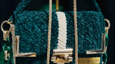 a green purse with a chain link chain