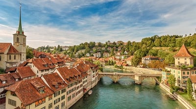 a river with a bridge and a church in the background