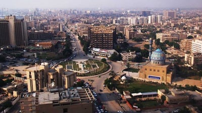 a cityscape of a city with a lot of cars parked in front of