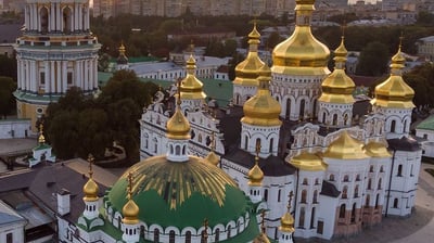 a large white and gold building with a green dome