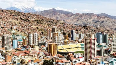 a cityscape of buildings and mountains in the background