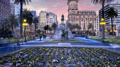 a cityscape of a city with a fountain and palm trees