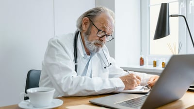 a male doctor in a white coat and a laptop
