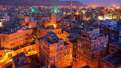 a cityscape of buildings and mountains in the distance