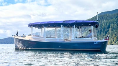 an eco-friendly boat with a blue canopy over it on Quilcene Bay