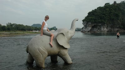 Tracey Billington on an elephant  by the river in Guilin, China