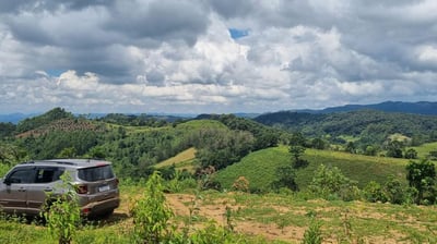 a car parked on a hill with a view of the mountains