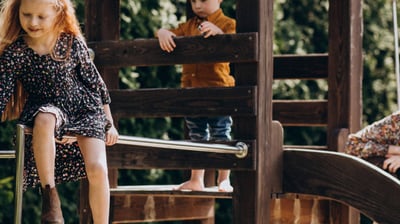 enfant jouant sur une cabane en bois