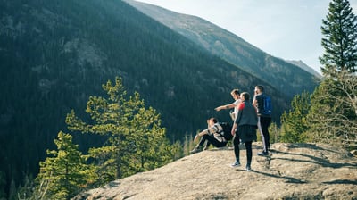 Friends exploring a scenic trail together, laughing and solving challenges