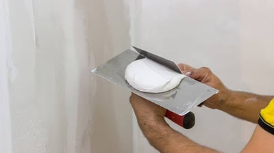 Изглаждане на стена с шпакловка за подготовка преди боядисване или облицовка.