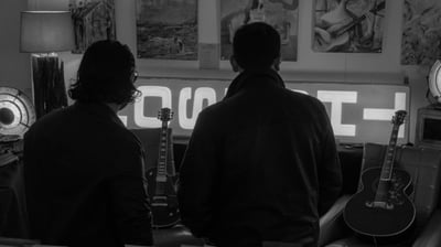Deux hommes regardent des guitares