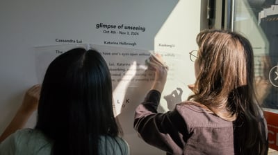 two women are standing in front of a sign