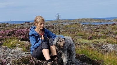 The Dog-Walker sitting on a rock in the moorland, comforting a grey fluffy Dog