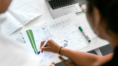 Equipe analisando planta de projeto técnico personalizado sobre a mesa