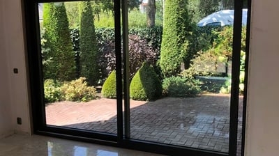 Technicien nettoyant une baie vitrée avec des outils professionnels pour un résultat transparent